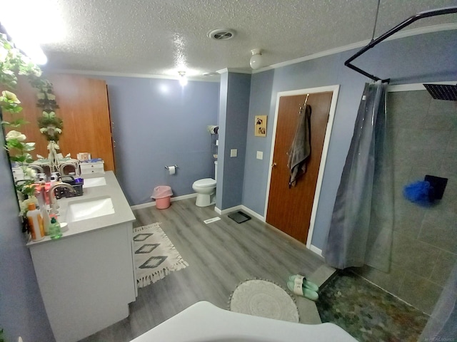 bathroom featuring hardwood / wood-style flooring, toilet, ornamental molding, vanity, and a shower with shower curtain