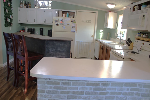 kitchen featuring kitchen peninsula, white cabinetry, sink, and white appliances