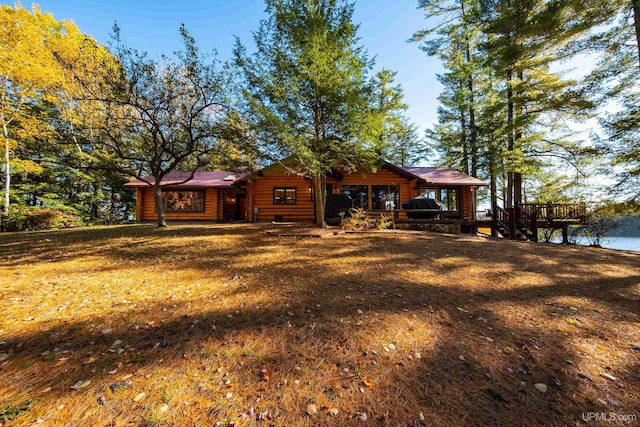 log home with a front yard and a water view