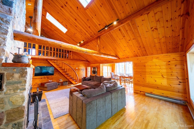 living room with light hardwood / wood-style flooring, high vaulted ceiling, and a skylight