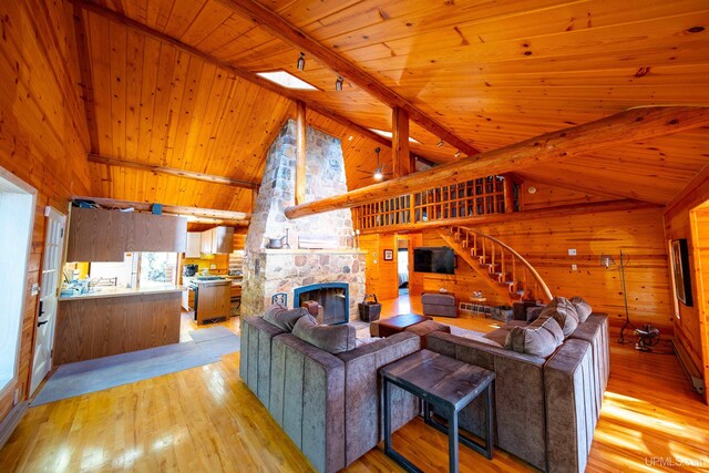 living room featuring wood ceiling, light hardwood / wood-style floors, beam ceiling, and wooden walls