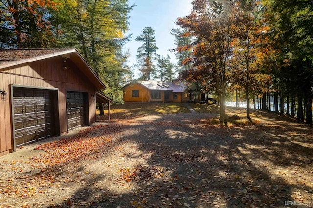 view of side of home with an outbuilding, a garage, and a water view