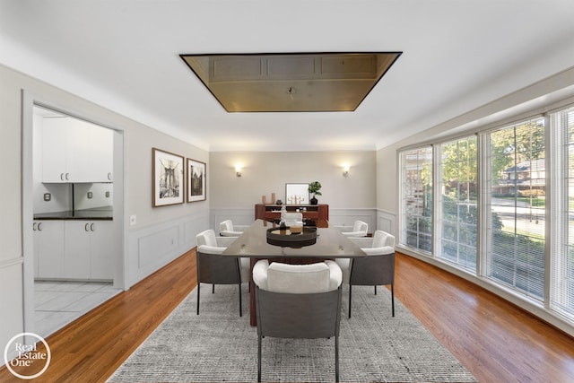 dining room with wainscoting and light wood-style flooring