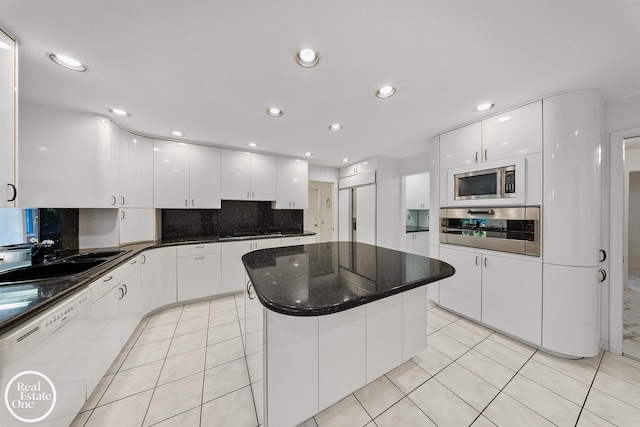 kitchen with built in appliances, backsplash, white cabinetry, and a kitchen island