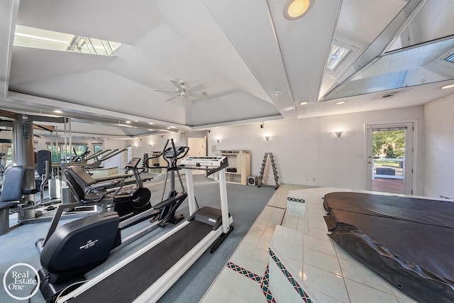 exercise room with tile patterned floors, a ceiling fan, recessed lighting, and a raised ceiling
