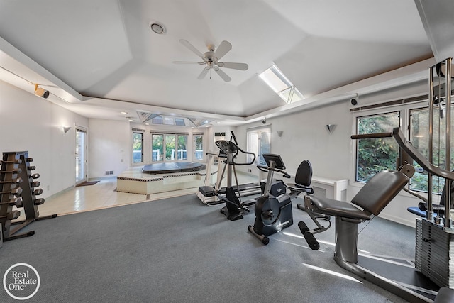exercise room featuring ceiling fan, baseboards, and a tray ceiling