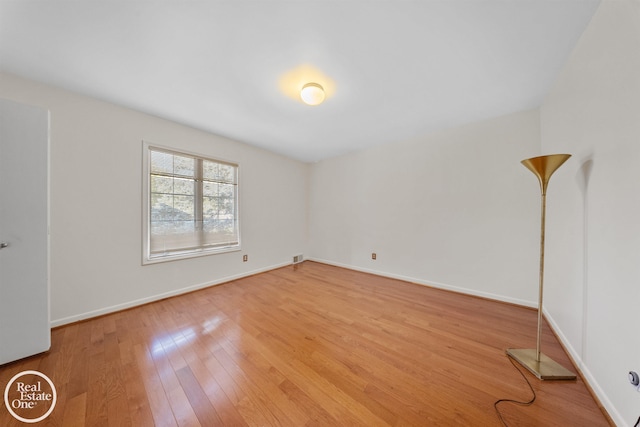 unfurnished room featuring wood-type flooring and baseboards