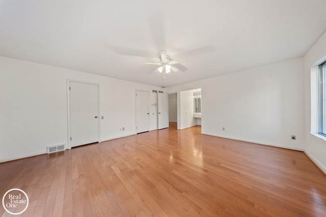 unfurnished bedroom featuring a ceiling fan, light wood-style floors, two closets, baseboards, and visible vents