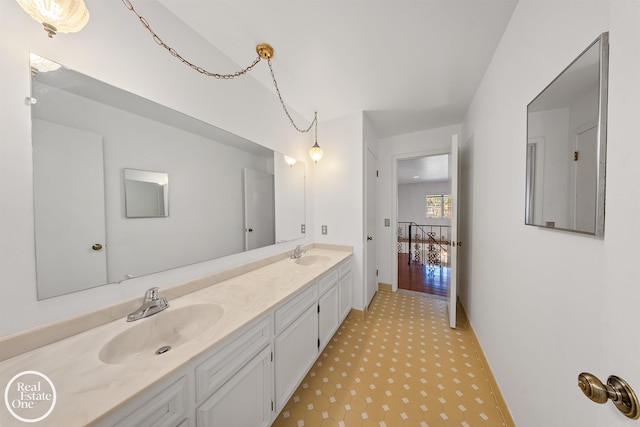 bathroom with tile patterned floors, a sink, and double vanity
