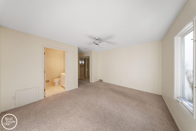 empty room featuring ceiling fan, light carpet, visible vents, and baseboards