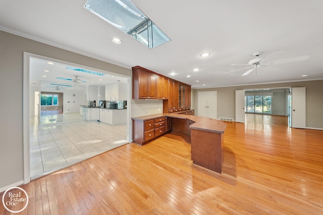 kitchen with ceiling fan, open floor plan, and ornamental molding
