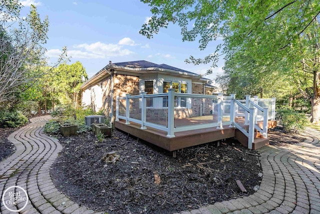 back of house featuring a sunroom, a deck, and cooling unit