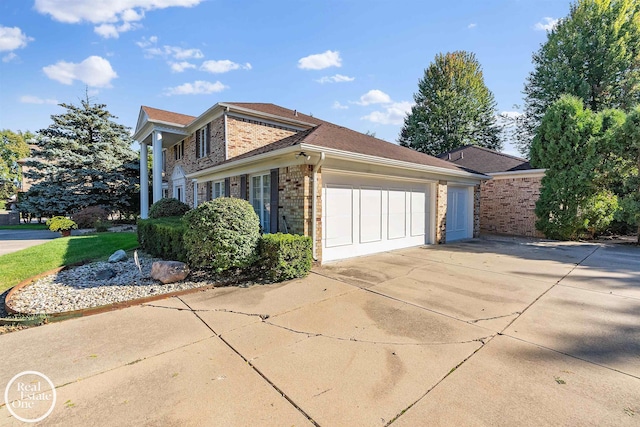 view of home's exterior with concrete driveway, brick siding, and a garage