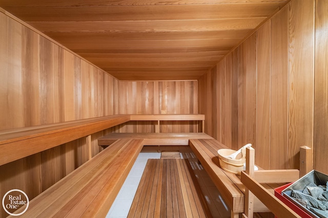 view of sauna featuring wood ceiling and wood walls