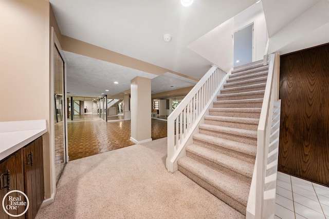 stairway with baseboards and carpet floors