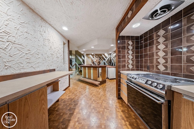 kitchen featuring black electric range oven and a textured ceiling