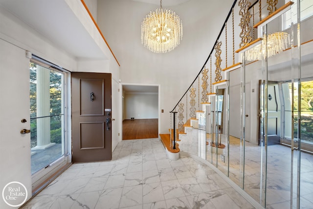 foyer entrance with a chandelier, stairway, a high ceiling, and marble finish floor