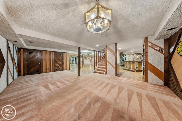 interior space with a textured ceiling, a notable chandelier, and carpet flooring