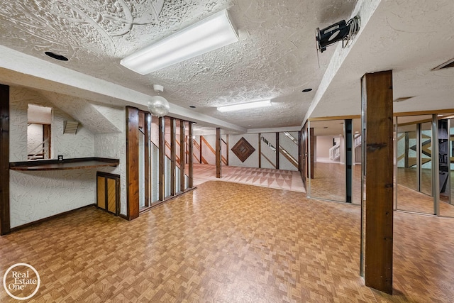 basement with a textured ceiling and parquet floors