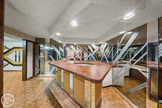 interior space with recessed lighting, a textured ceiling, and wooden counters