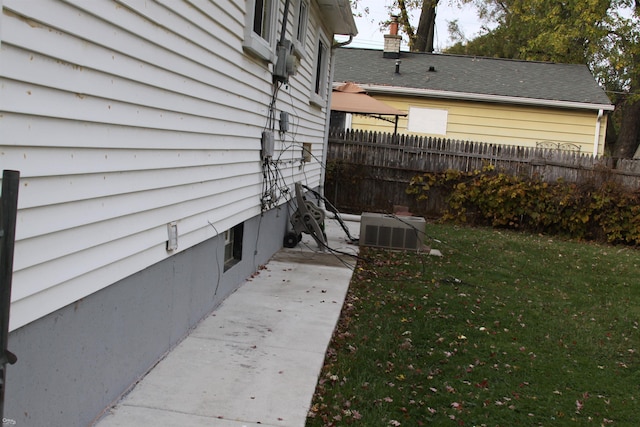 view of property exterior with a yard and central AC