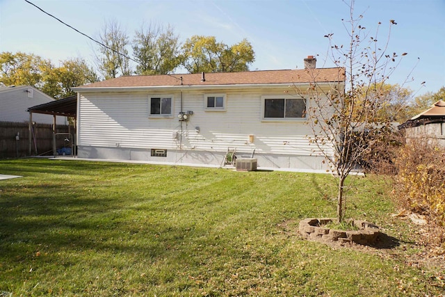 rear view of property featuring a lawn and central AC unit