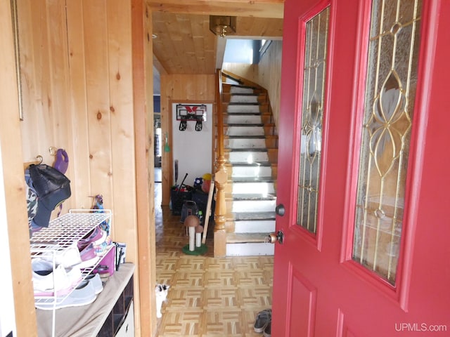 foyer entrance featuring wood walls and light parquet floors