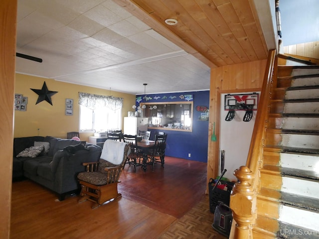 living room with a notable chandelier, wood walls, and hardwood / wood-style flooring