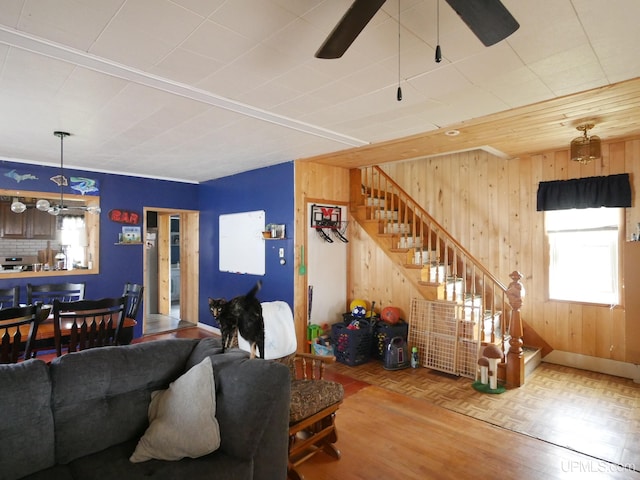 living room with parquet floors, wooden walls, and ceiling fan