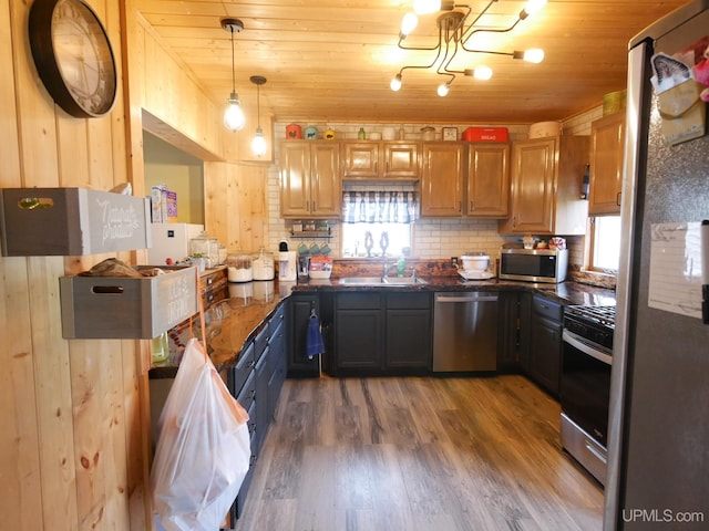 kitchen with appliances with stainless steel finishes, wooden ceiling, wooden walls, and wood-type flooring