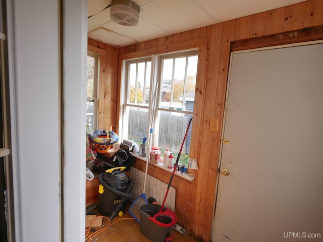 entryway featuring wooden walls and parquet floors