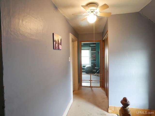 corridor with light carpet and vaulted ceiling