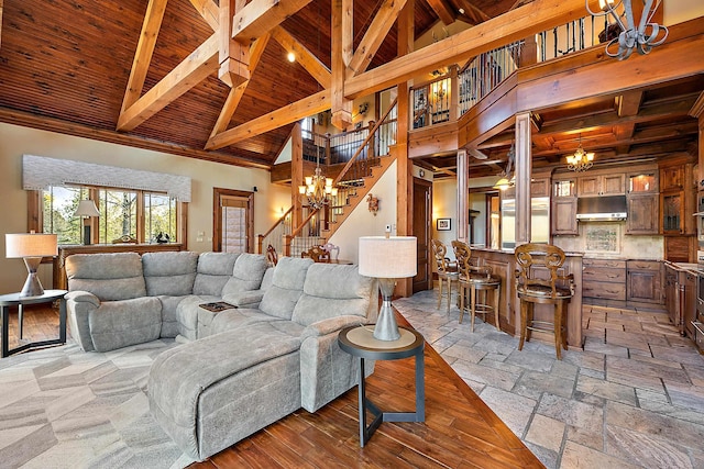 living room with a notable chandelier, beam ceiling, high vaulted ceiling, and wooden ceiling