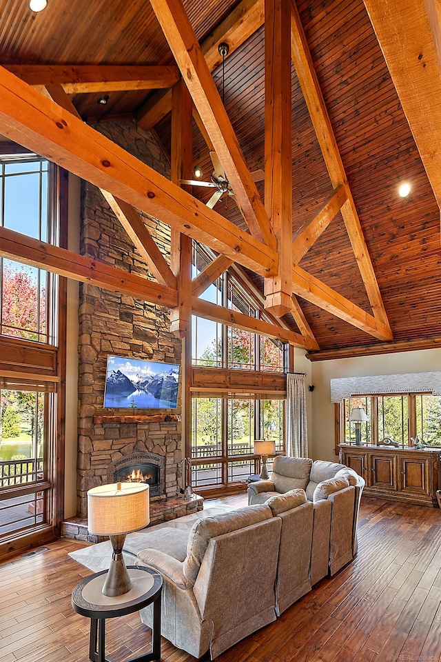 living room featuring light hardwood / wood-style flooring, a healthy amount of sunlight, and high vaulted ceiling