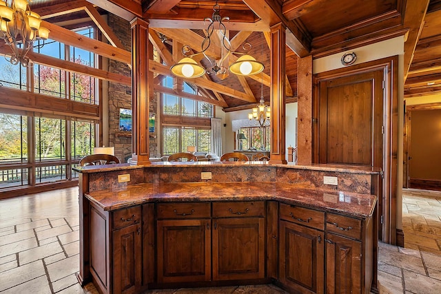 kitchen with a kitchen island, pendant lighting, dark stone countertops, beam ceiling, and high vaulted ceiling