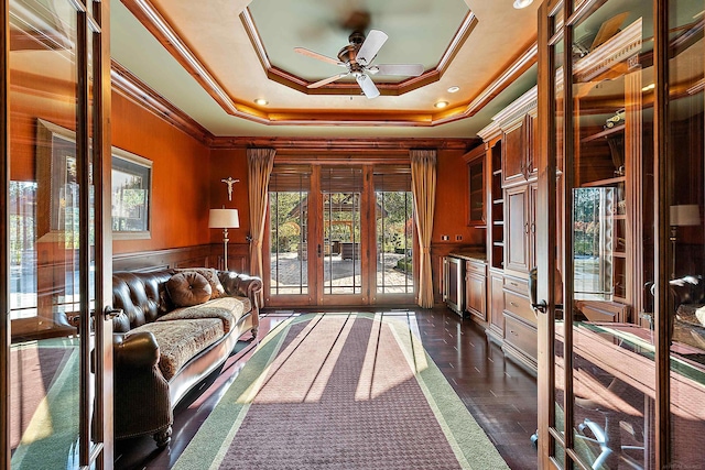 unfurnished room featuring french doors, crown molding, a raised ceiling, dark hardwood / wood-style flooring, and ceiling fan