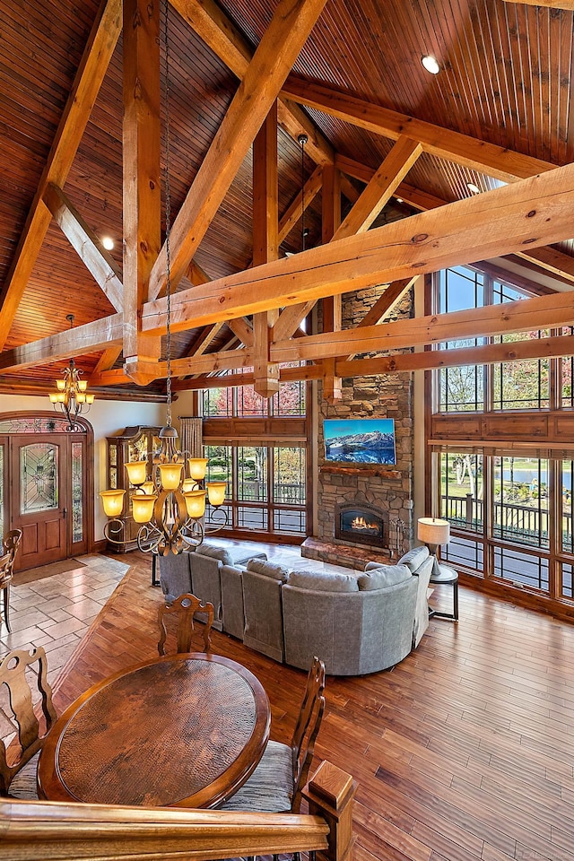 living room featuring a healthy amount of sunlight, high vaulted ceiling, wood-type flooring, and a fireplace