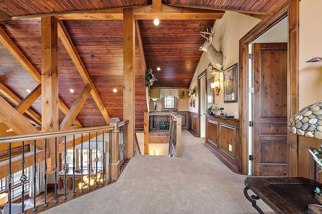 hall featuring carpet, vaulted ceiling with beams, and wooden ceiling