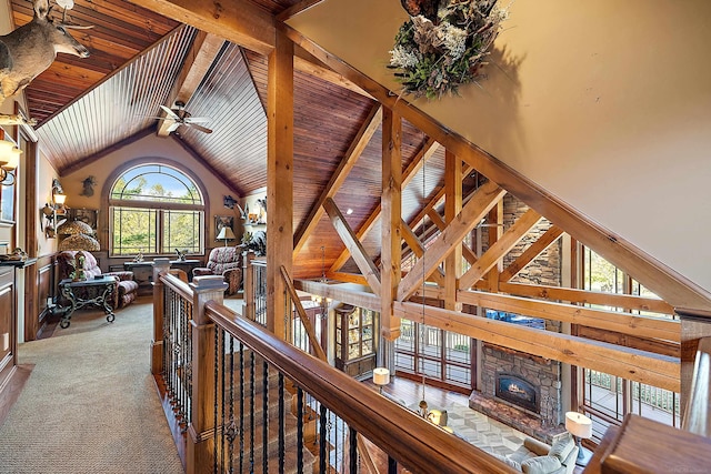 hallway featuring beamed ceiling, a healthy amount of sunlight, high vaulted ceiling, and carpet flooring