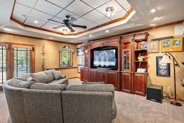 home theater room featuring ceiling fan, a raised ceiling, carpet, and ornamental molding