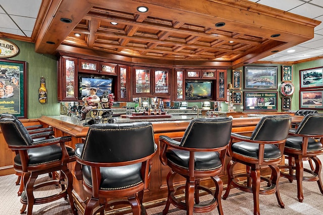 bar featuring coffered ceiling and light colored carpet