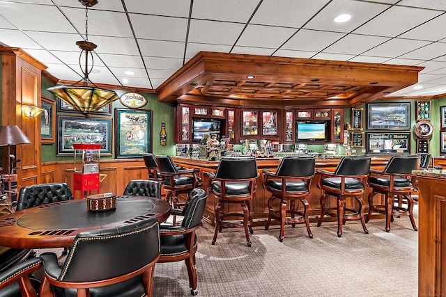 bar featuring light carpet and decorative light fixtures