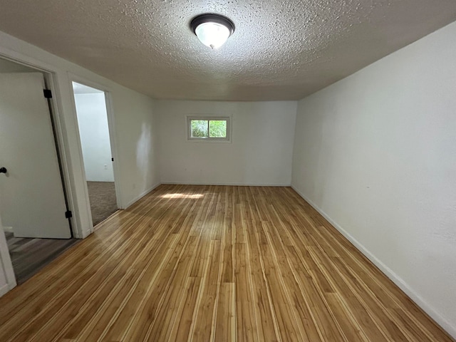 spare room featuring hardwood / wood-style flooring and a textured ceiling