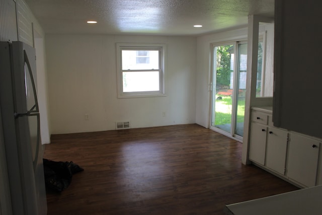 interior space with a textured ceiling and dark wood-type flooring