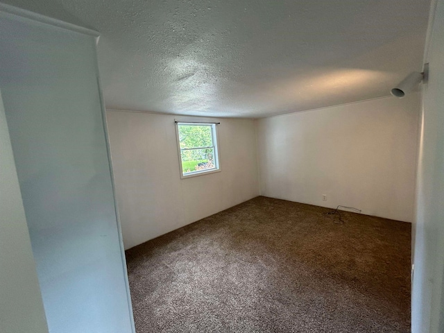 carpeted empty room featuring a textured ceiling