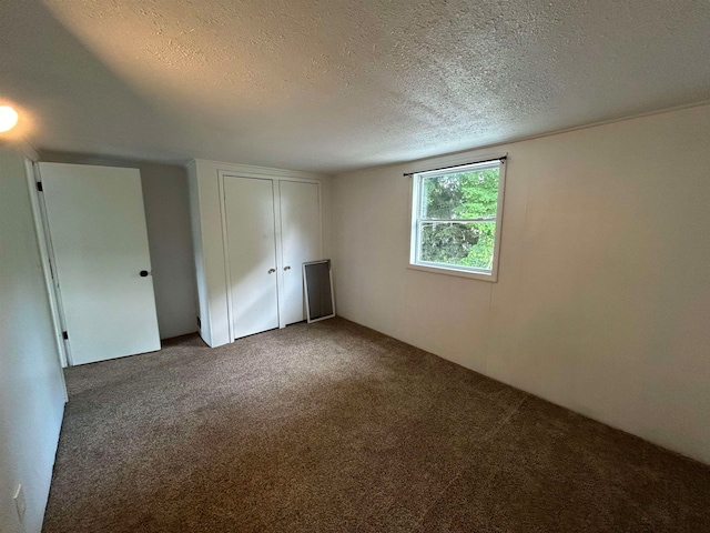 unfurnished bedroom featuring a textured ceiling and carpet