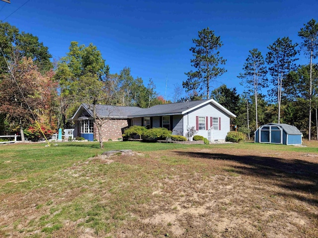 view of front of home featuring a front yard and a shed