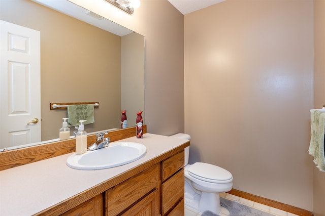 bathroom featuring toilet, vanity, and tile patterned floors