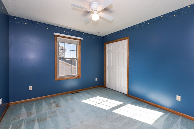 unfurnished bedroom featuring carpet, a closet, and ceiling fan