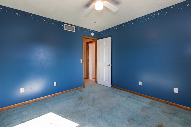 carpeted spare room featuring ceiling fan